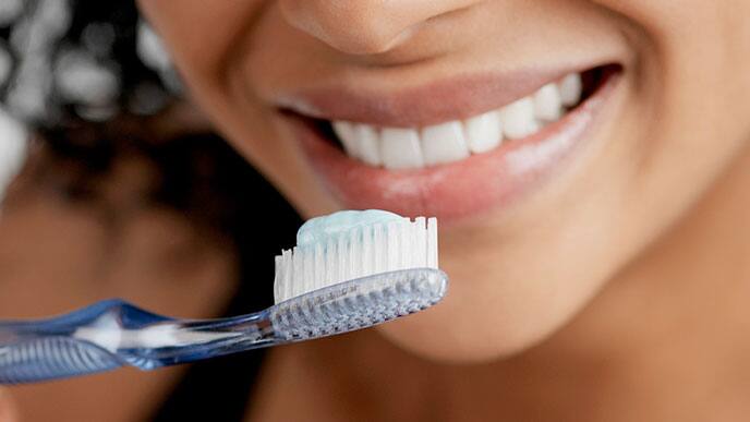 woman brushing with stannous fluoride toothpaste